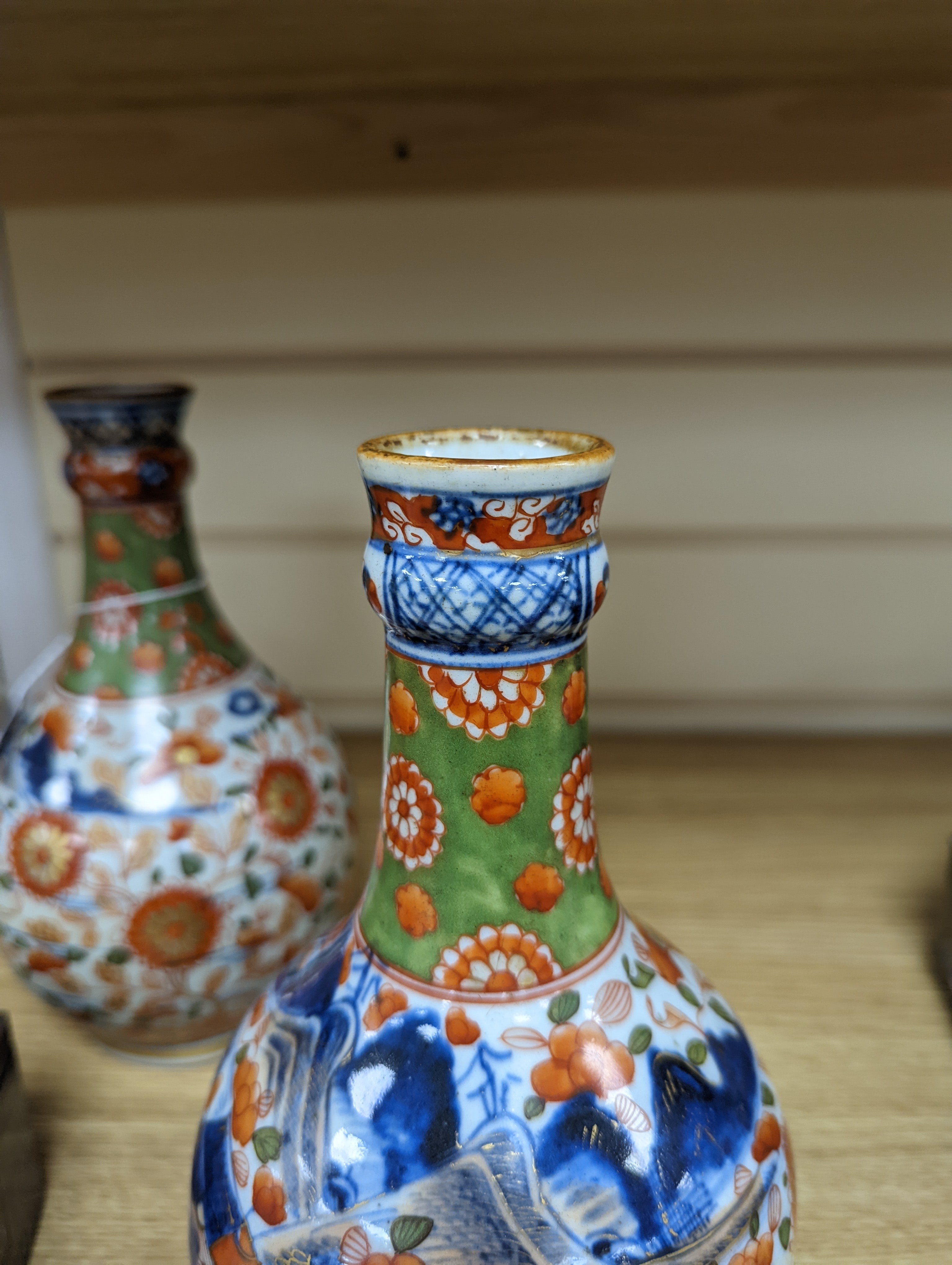 A pair of 18th century Chinese clobbered blue and white bottle vases 23cm